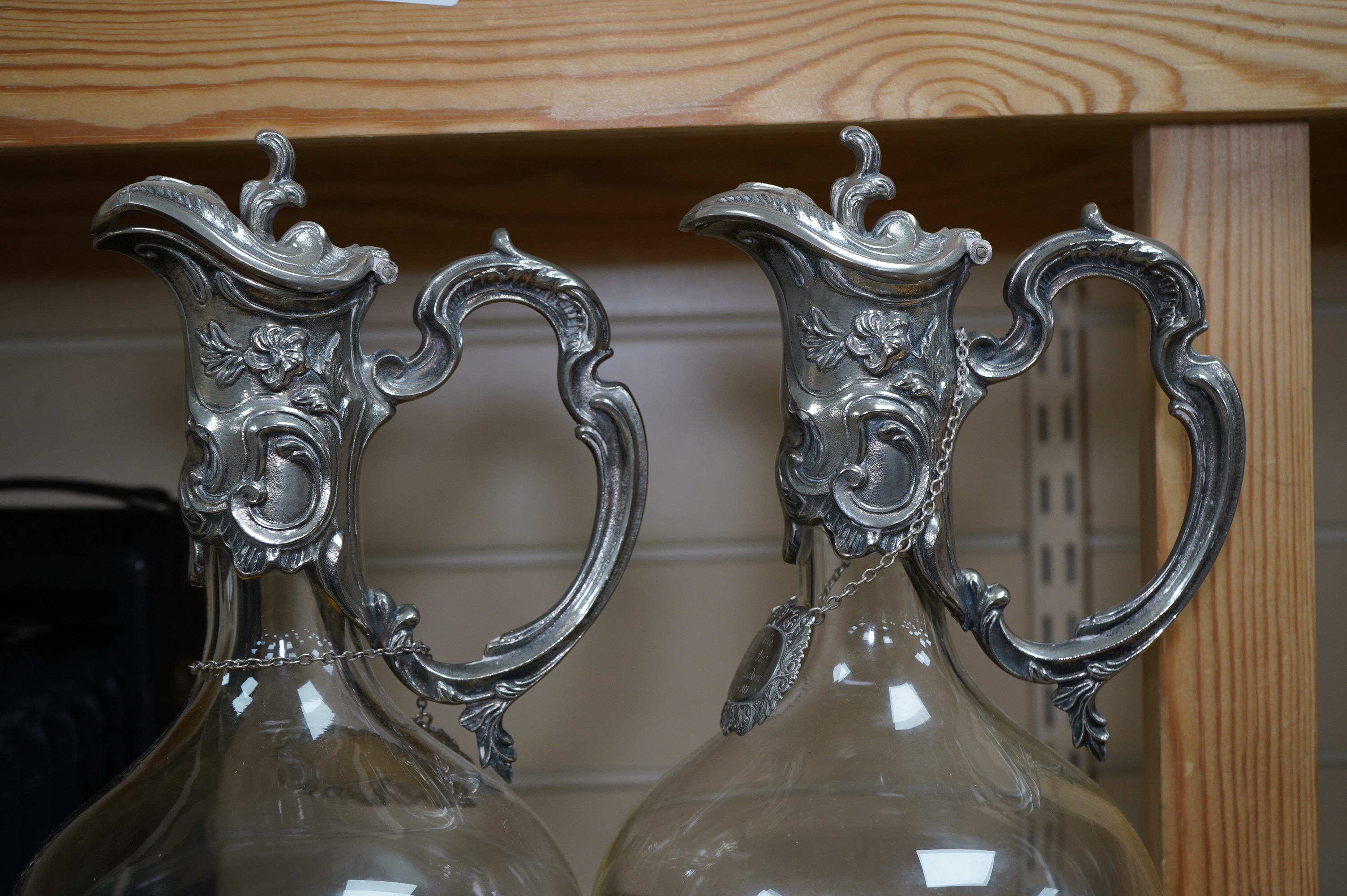 A pair of Art Nouveau silver plate mounted claret jugs with labels, 32cm. Condition - fair to good
